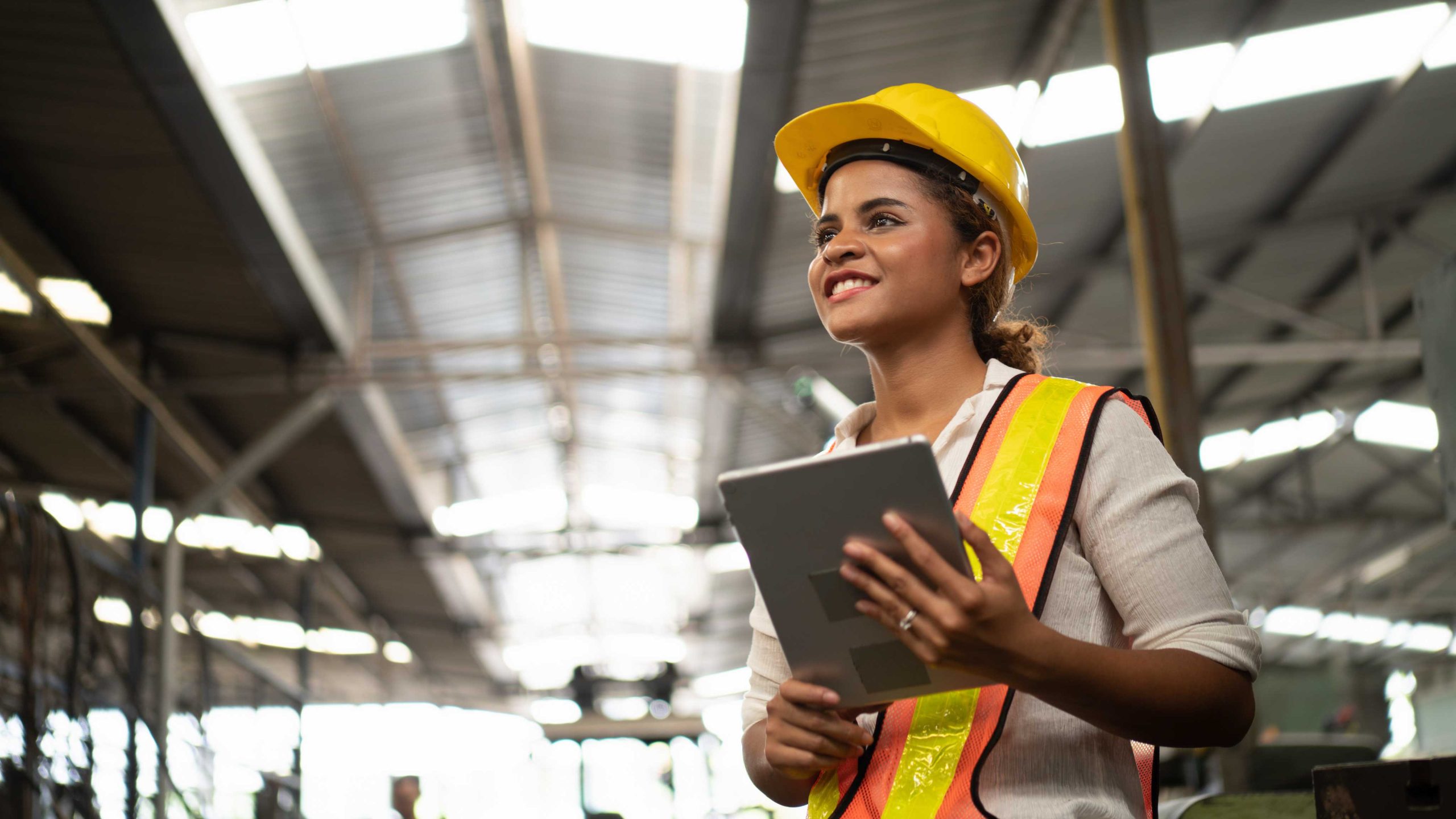 Portrait of industrial worker standing with tablet holding in her hand feeling proud and confident